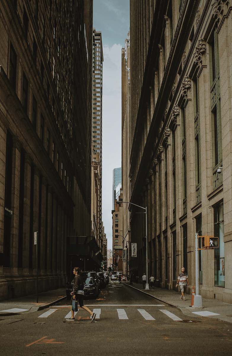urban woman walking on street between building during daytime building